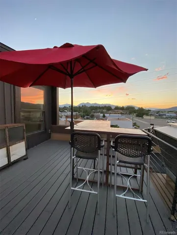 an outdoor sitting area with furniture and wooden floor