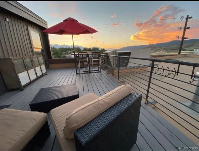 a balcony with wooden floor table and chairs