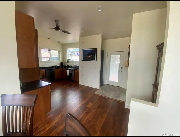 a view of a living room with wooden floor and a kitchen