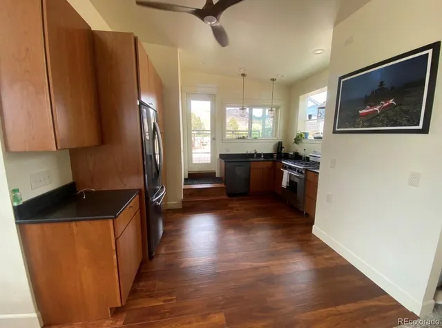 a kitchen with stainless steel appliances granite countertop a refrigerator a stove top oven a sink and dishwasher