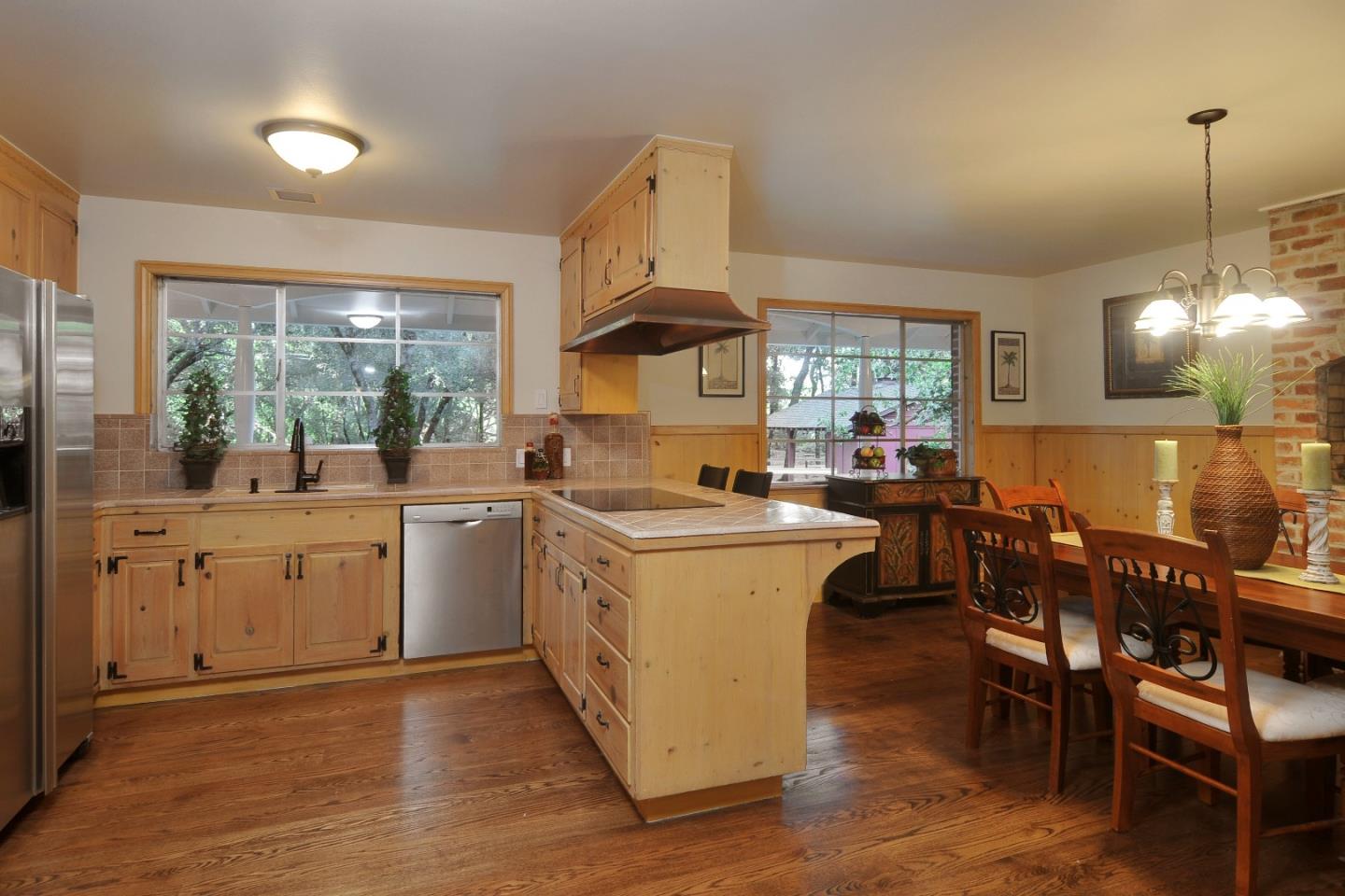 3470 Tripp Road Woodside, CA 94062 - Photo 6 of 34 a kitchen that has a lot of cabinets in it with a dining table and chairs