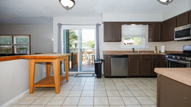a kitchen with stainless steel appliances granite countertop a stove a sink and a microwave