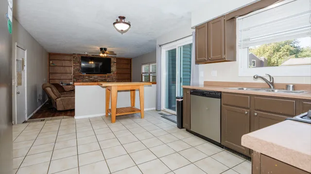 a kitchen with stainless steel appliances a sink cabinets and a window
