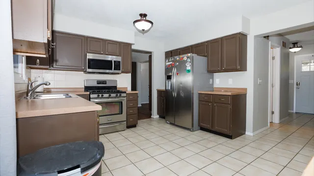 a kitchen with stainless steel appliances granite countertop a refrigerator stove and sink