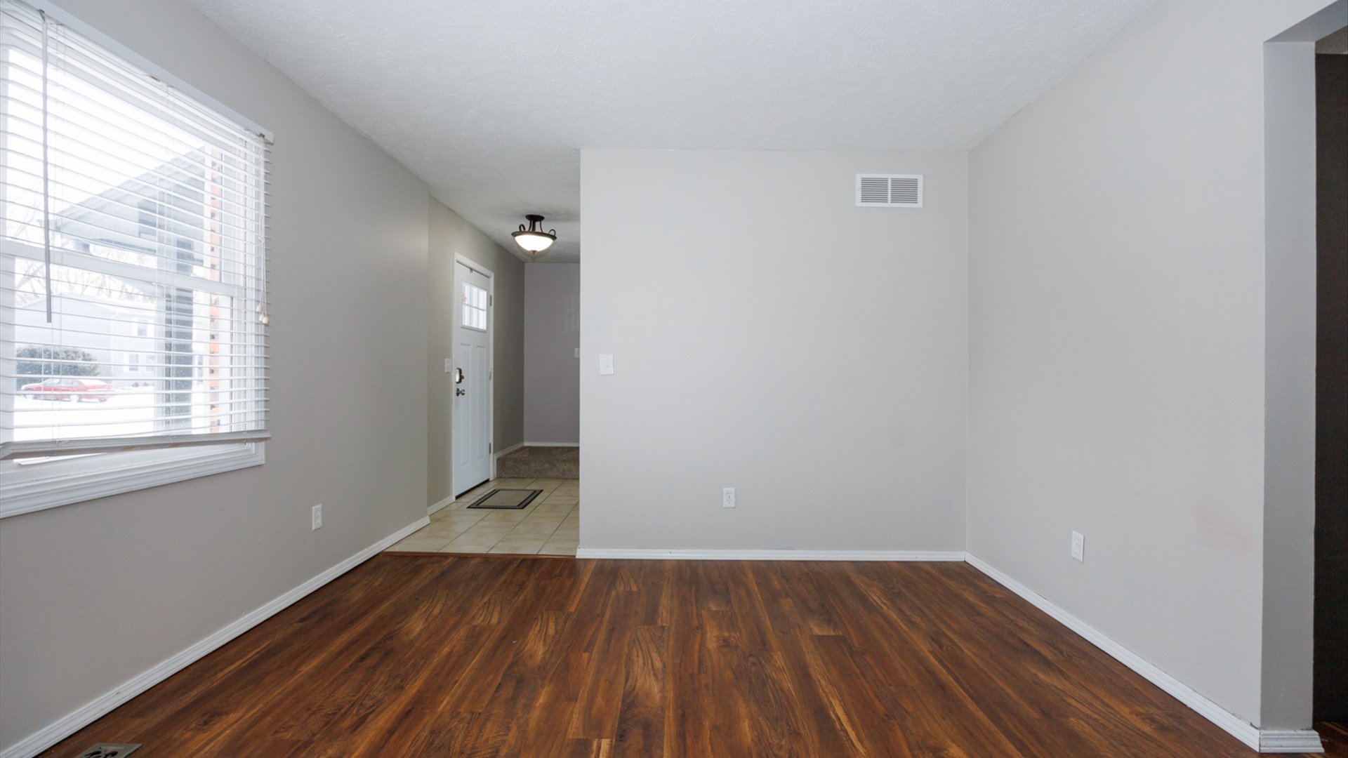 2007 Fallen Oak Road Bloomington, IL 61704 - Photo 7 of 44 a view of an empty room with wooden floor and a window