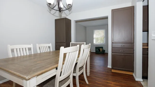 a dining room with wooden floor table and chairs