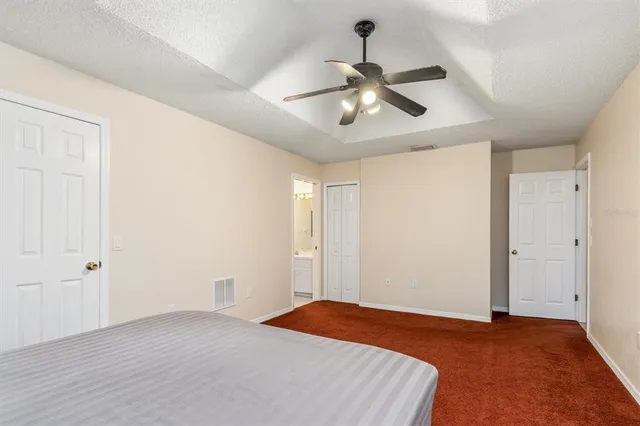 a bedroom with a bed and a chandelier fan