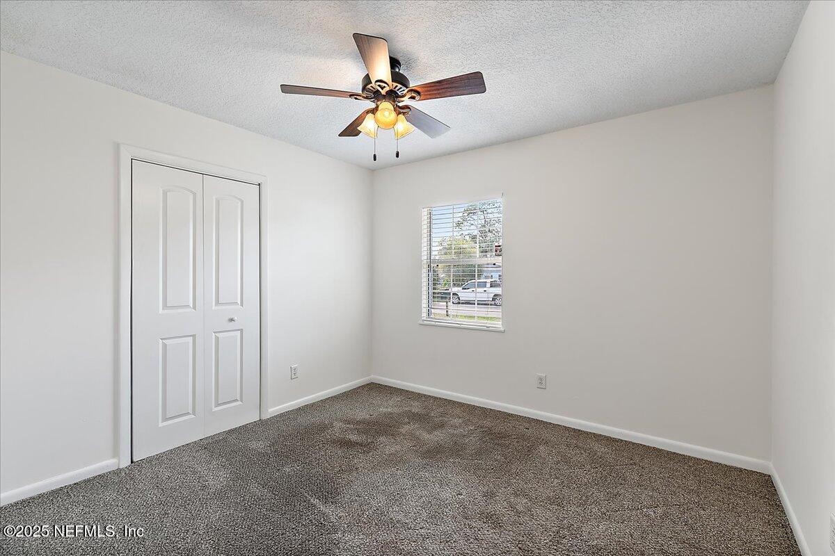 1879 George Street Atlantic Beach, FL 32233 - Photo 11 of 27 an empty room with window and ceiling fan