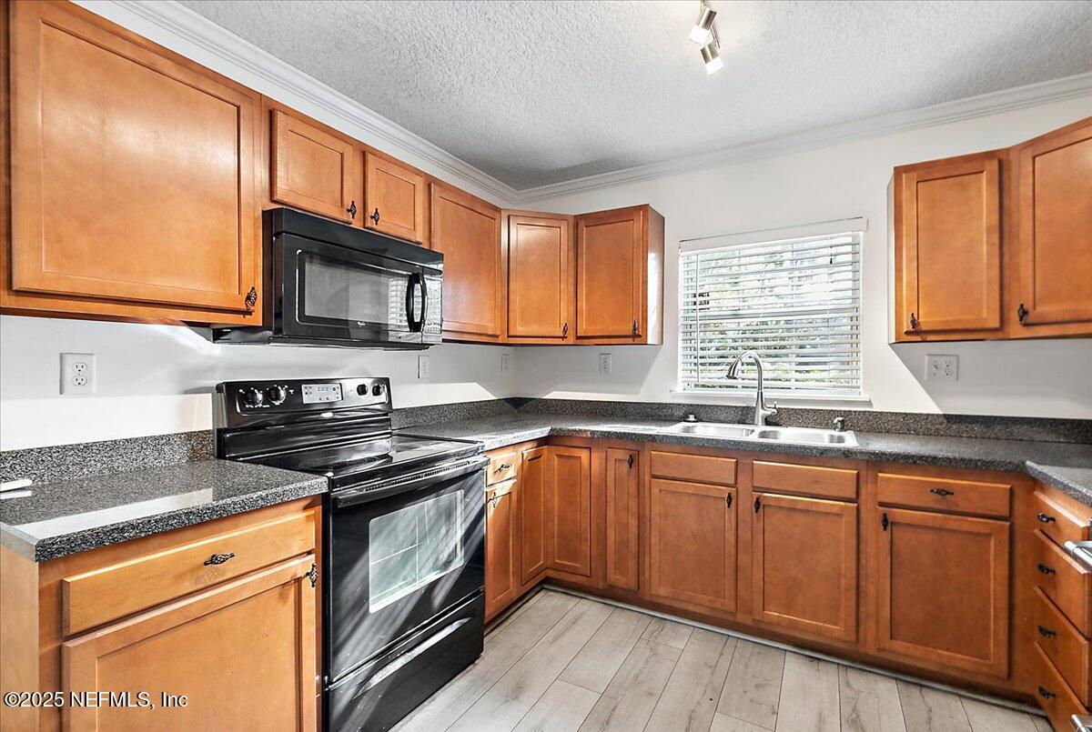 1879 George Street Atlantic Beach, FL 32233 - Photo 7 of 27 a kitchen with stainless steel appliances granite countertop wooden cabinets stove top oven and sink