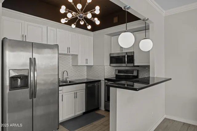 a kitchen with stainless steel appliances granite countertop a sink a refrigerator and a microwave