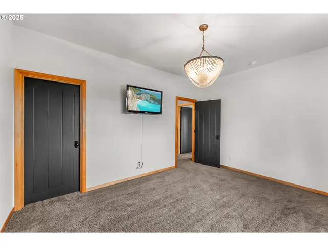 a view of an empty room with a chandelier fan