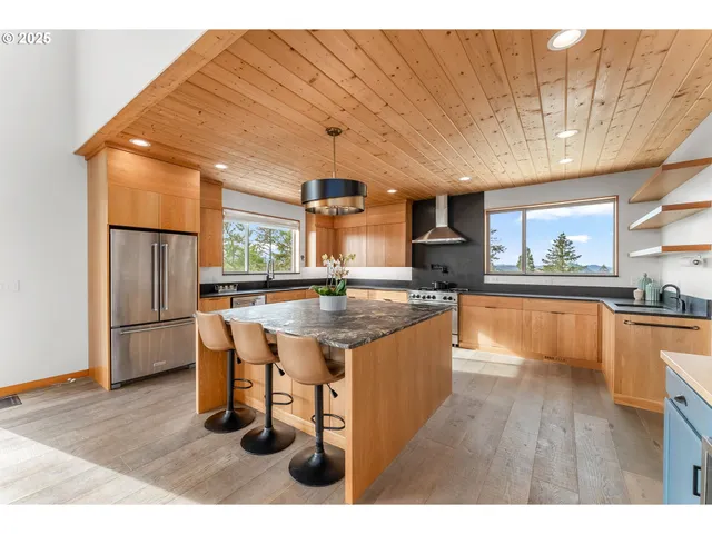 a kitchen with stainless steel appliances granite countertop a sink a stove and refrigerator