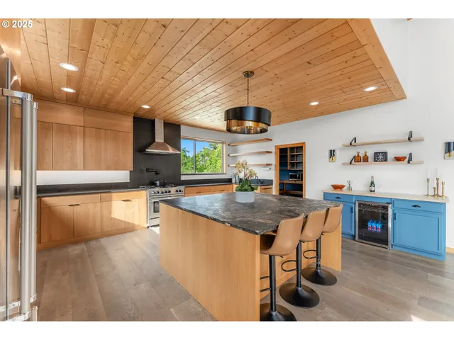 a kitchen with stainless steel appliances granite countertop a sink a stove and a refrigerator