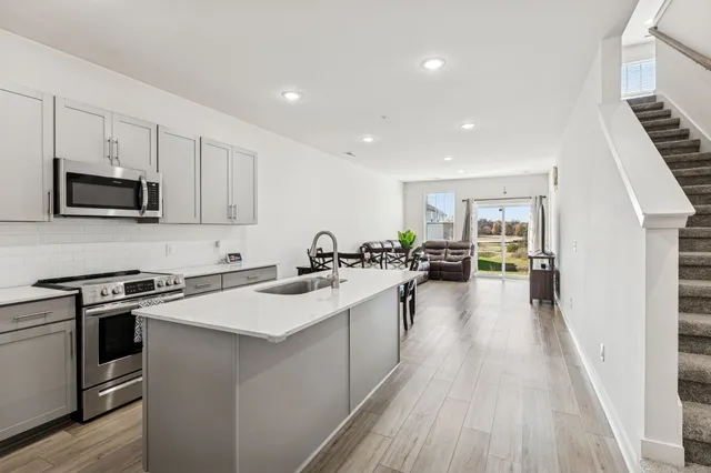 a kitchen with a sink stove and wooden floor