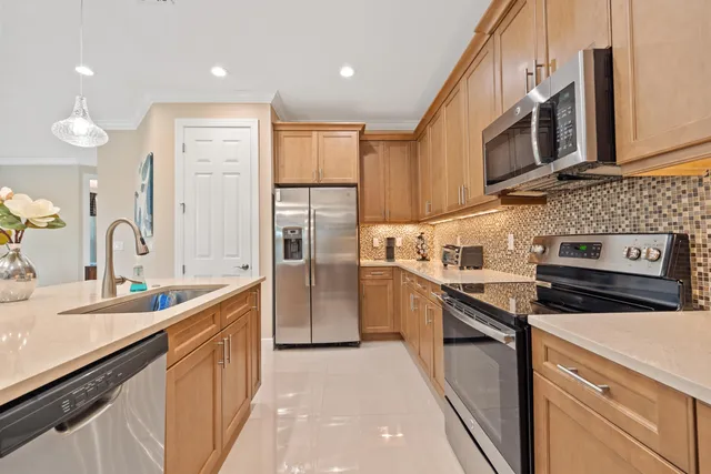 a kitchen with stainless steel appliances a sink stove and refrigerator