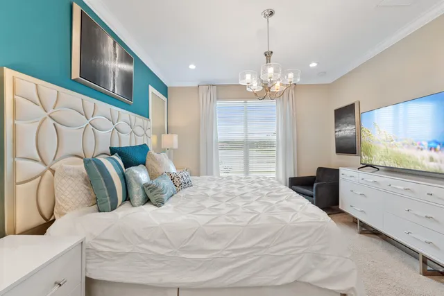 a bedroom with a large bed and a flat tv screen on dresser