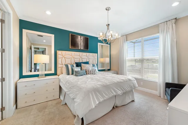 a spacious bedroom with a large bed and a chandelier