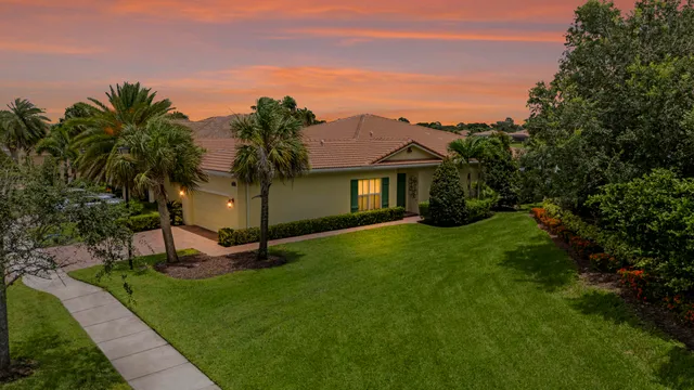 a front view of a house with a garden and tree