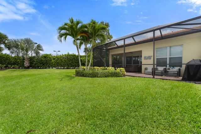 a palm tree sitting in front of a house with a yard