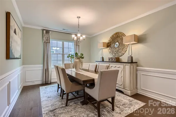 a dining room with furniture a chandelier and wooden floor
