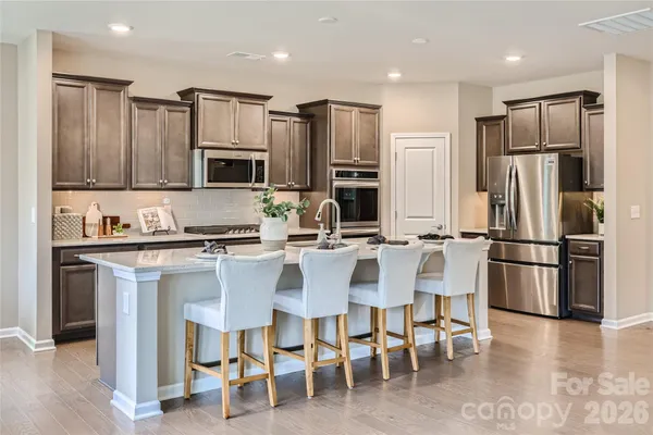 a kitchen with stainless steel appliances granite countertop a refrigerator and a stove top oven