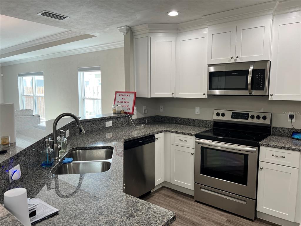 25107 Southwest 9th Lane Newberry, FL 32669 - Photo 2 of 9 a kitchen with stainless steel appliances granite countertop a stove a sink and a microwave