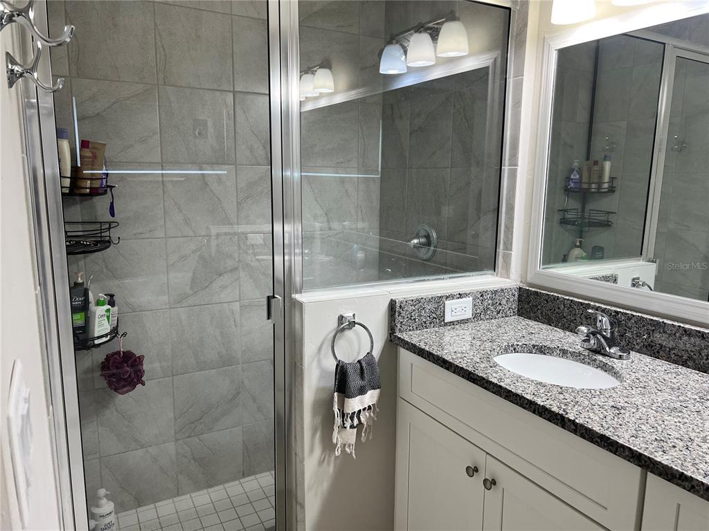 25107 Southwest 9th Lane Newberry, FL 32669 - Photo 4 of 9 a bathroom with a granite countertop shower sink and mirror