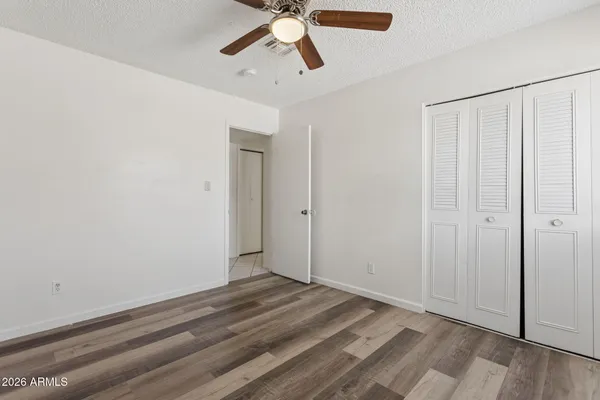an empty room with a window and ceiling fan