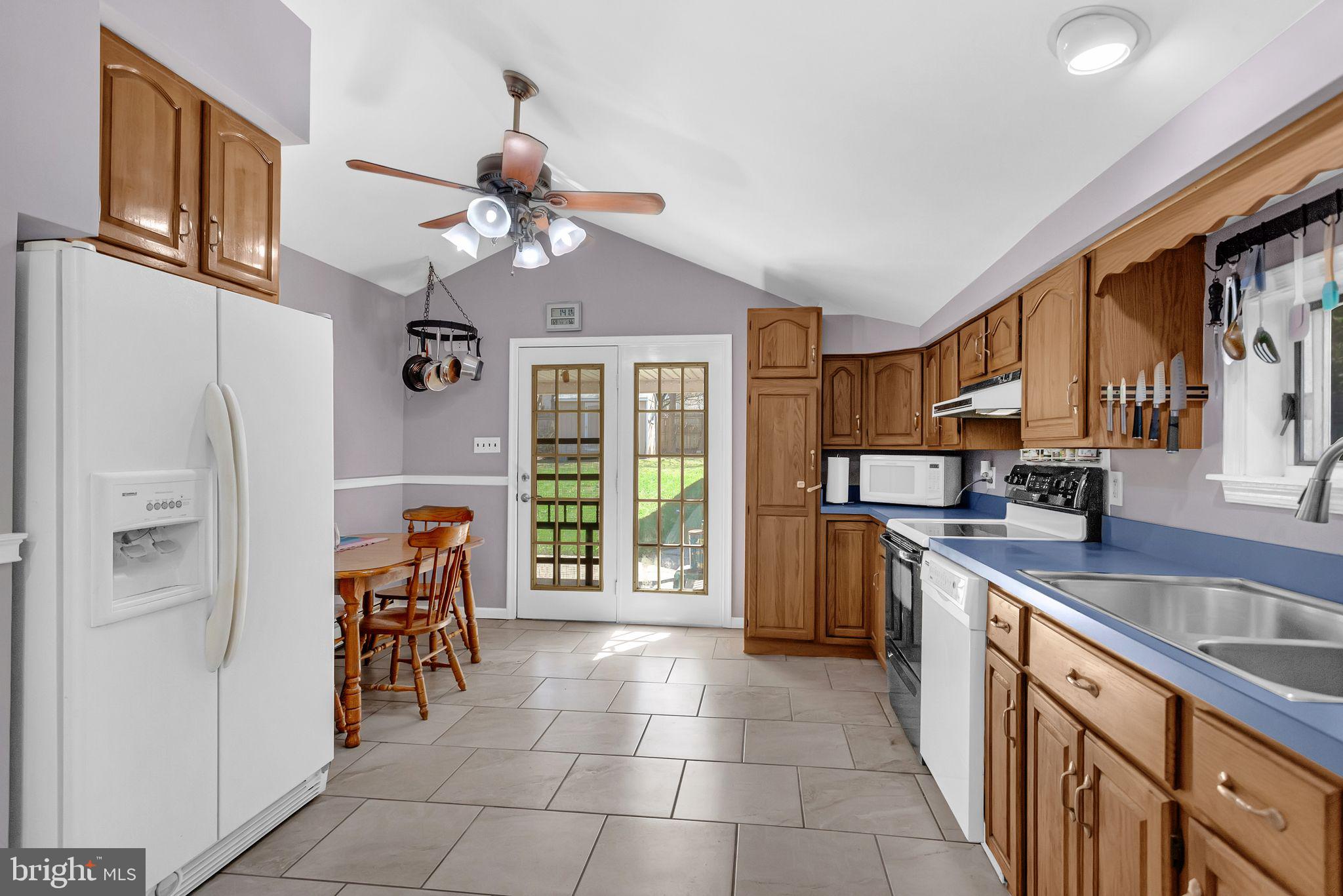 2775 Valley Road Jamison, PA 18929 - Photo 19 of 40 a kitchen with stainless steel appliances granite countertop a refrigerator a sink dishwasher a stove and a dining table with wooden floor