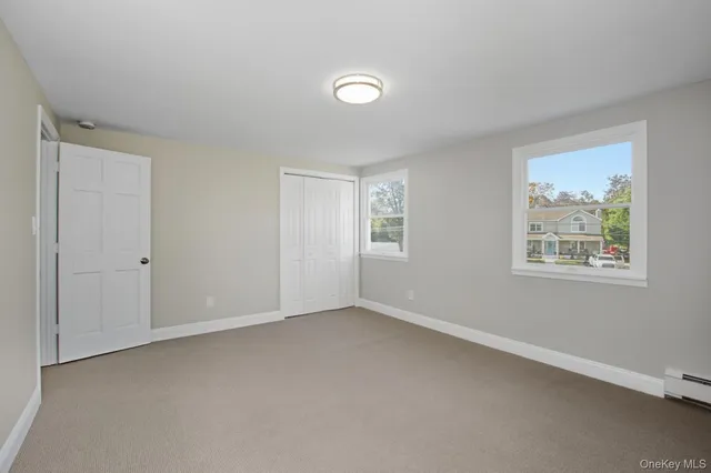an empty room with windows and closet