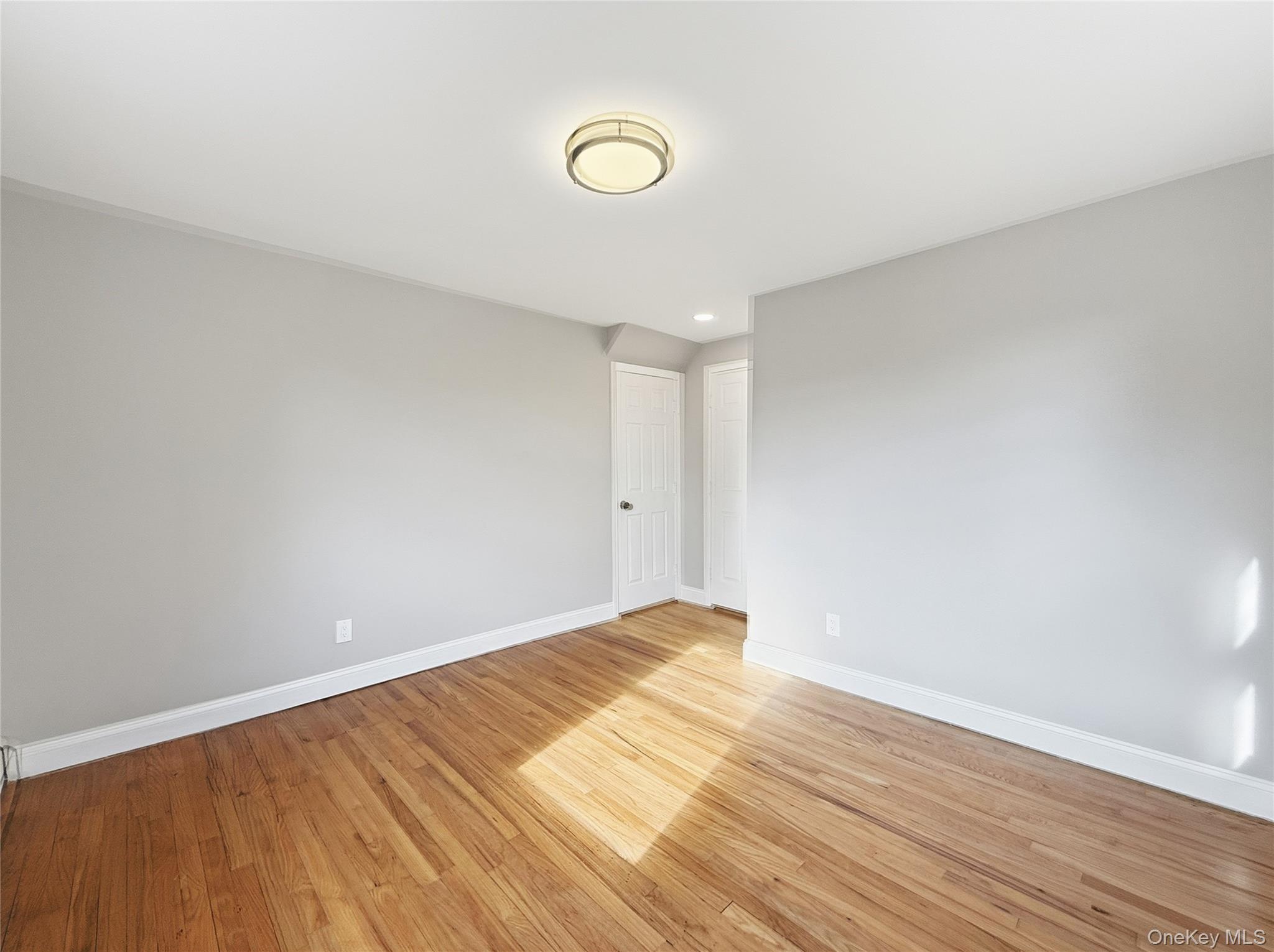 225 Lyman Road East Patchogue, NY 11772 - Photo 10 of 18 1st floor bedroom with ight wood finished floors and recessed lighting