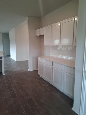 a kitchen with white cabinets and white appliances