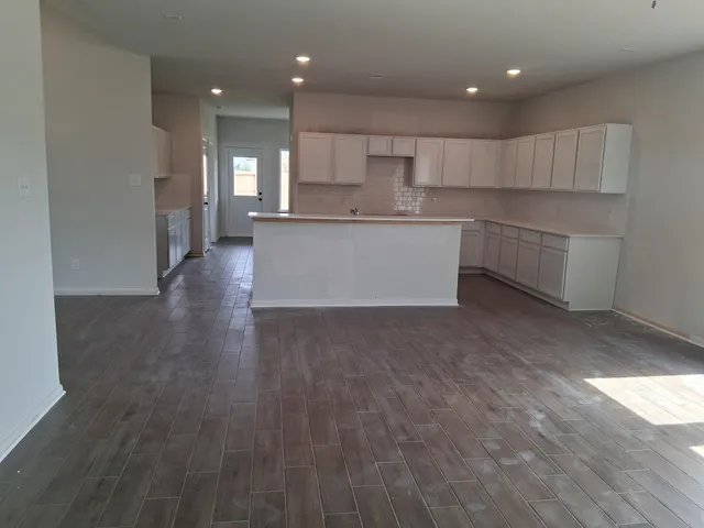 a large kitchen with stainless steel appliances refrigerator sink and cabinets