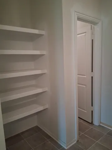 a view of walk in closet with empty racks