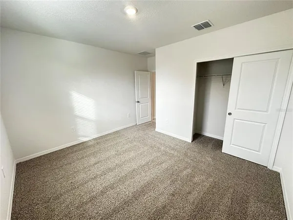 a view of an empty room and closet area