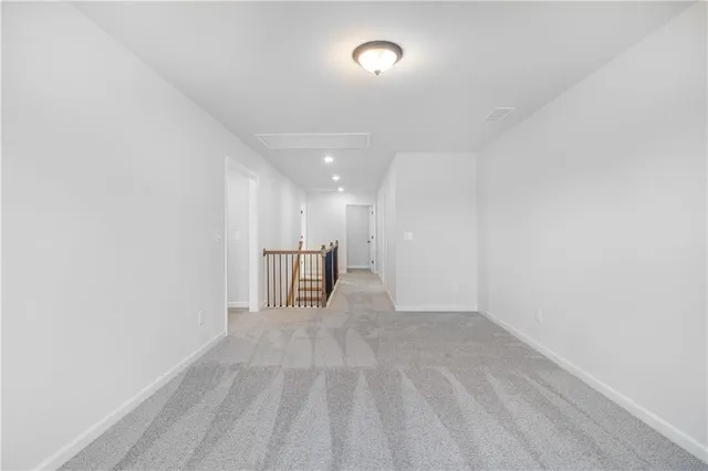 an empty room with wooden floor chandelier and windows