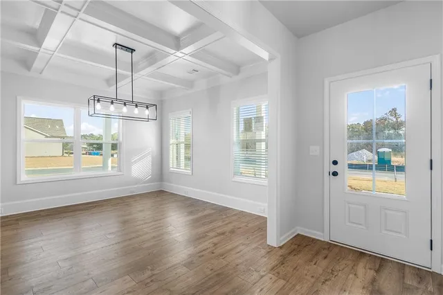 wooden floor fireplace and windows in an empty room