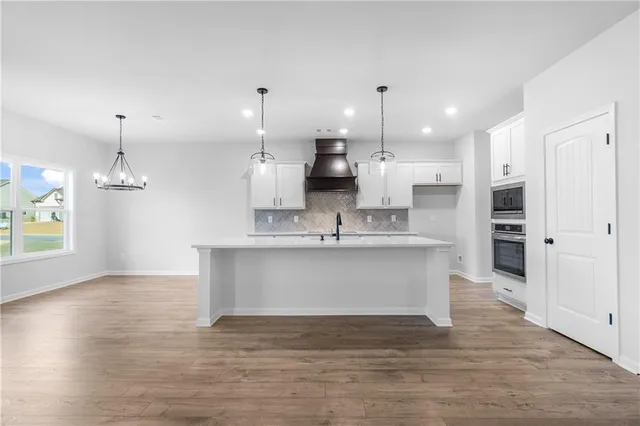 a kitchen with stainless steel appliances a sink stove and cabinets