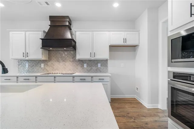 a kitchen with white cabinets sink and stove