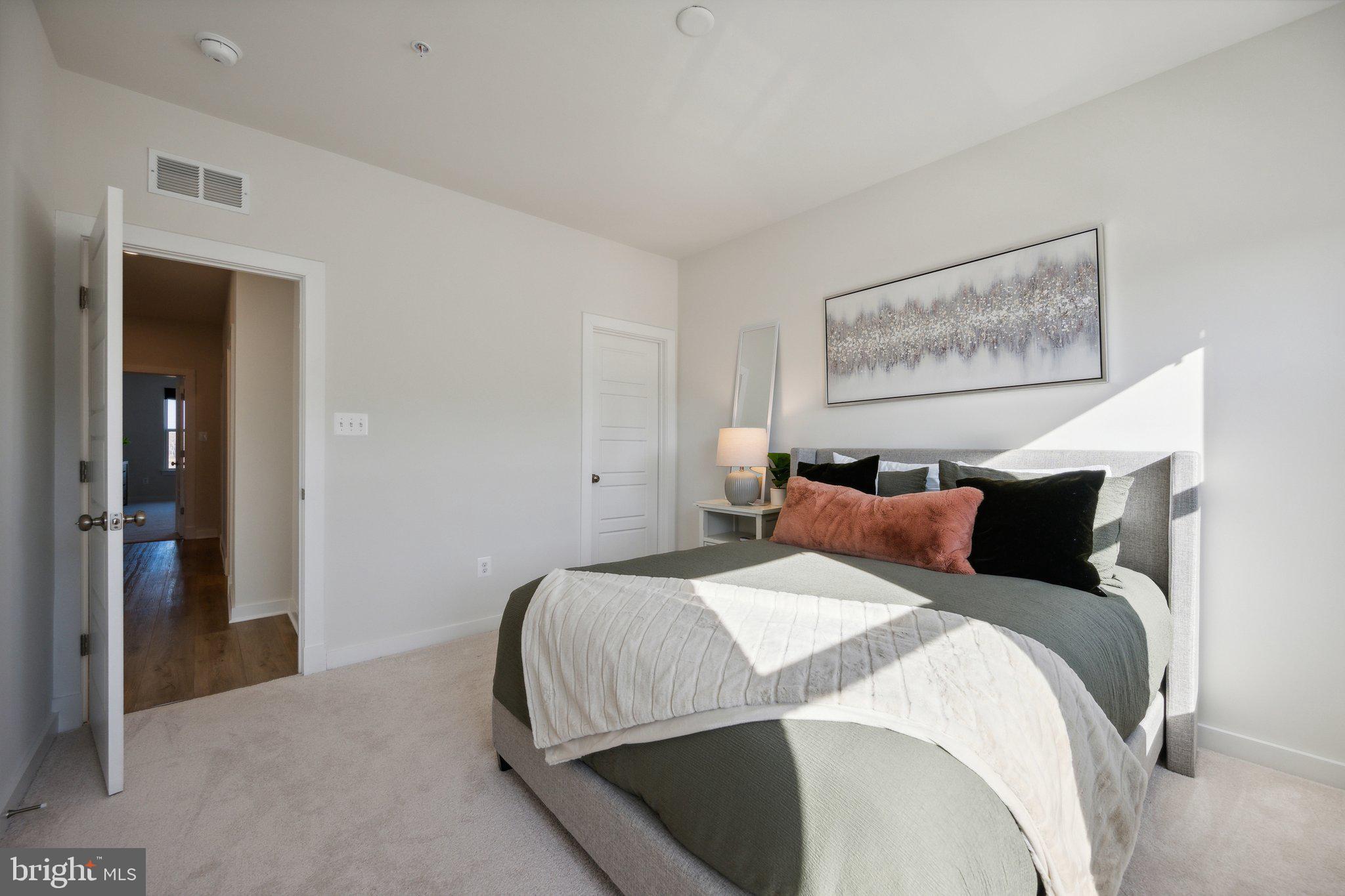 319 Summit Point Boulevard Bowie, MD 20716 - Photo 15 of 28 a bedroom with a bed and painting on the wall