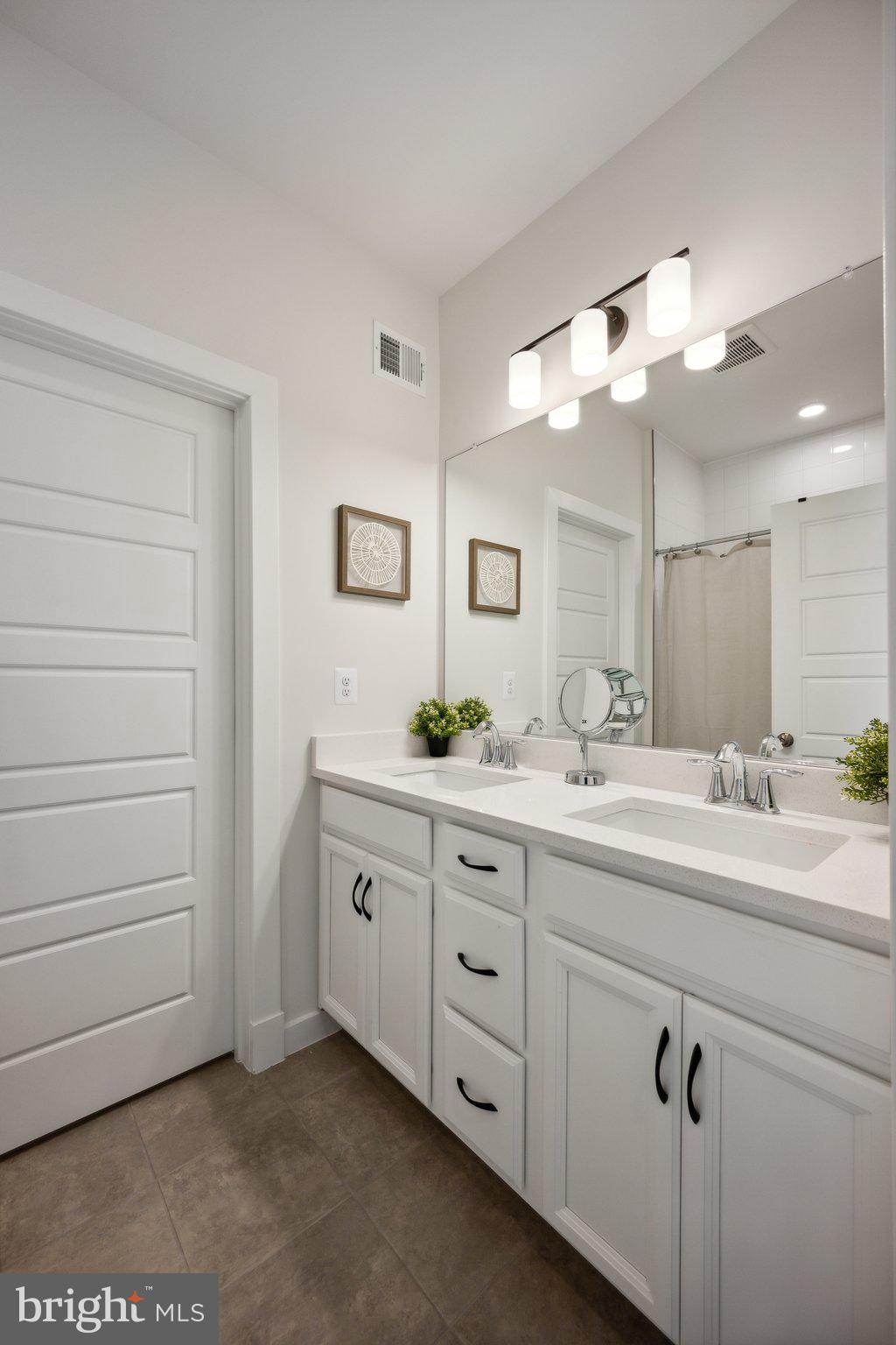 319 Summit Point Boulevard Bowie, MD 20716 - Photo 16 of 28 a bathroom with a double vanity sink a mirror and a bathtub