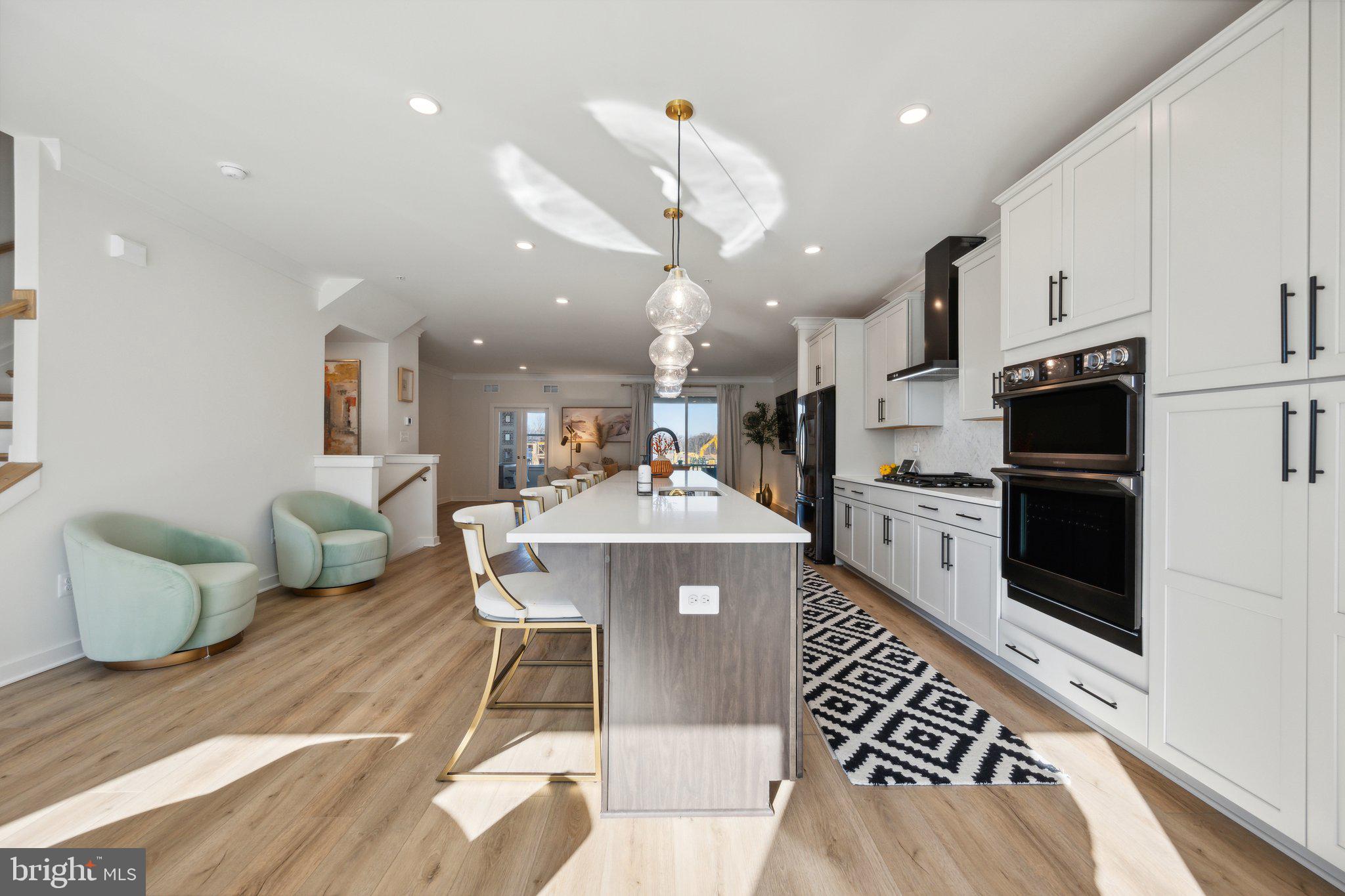 319 Summit Point Boulevard Bowie, MD 20716 - Photo 5 of 28 a kitchen with stainless steel appliances kitchen island granite countertop a refrigerator a stove a microwave oven a sink with island and chairs