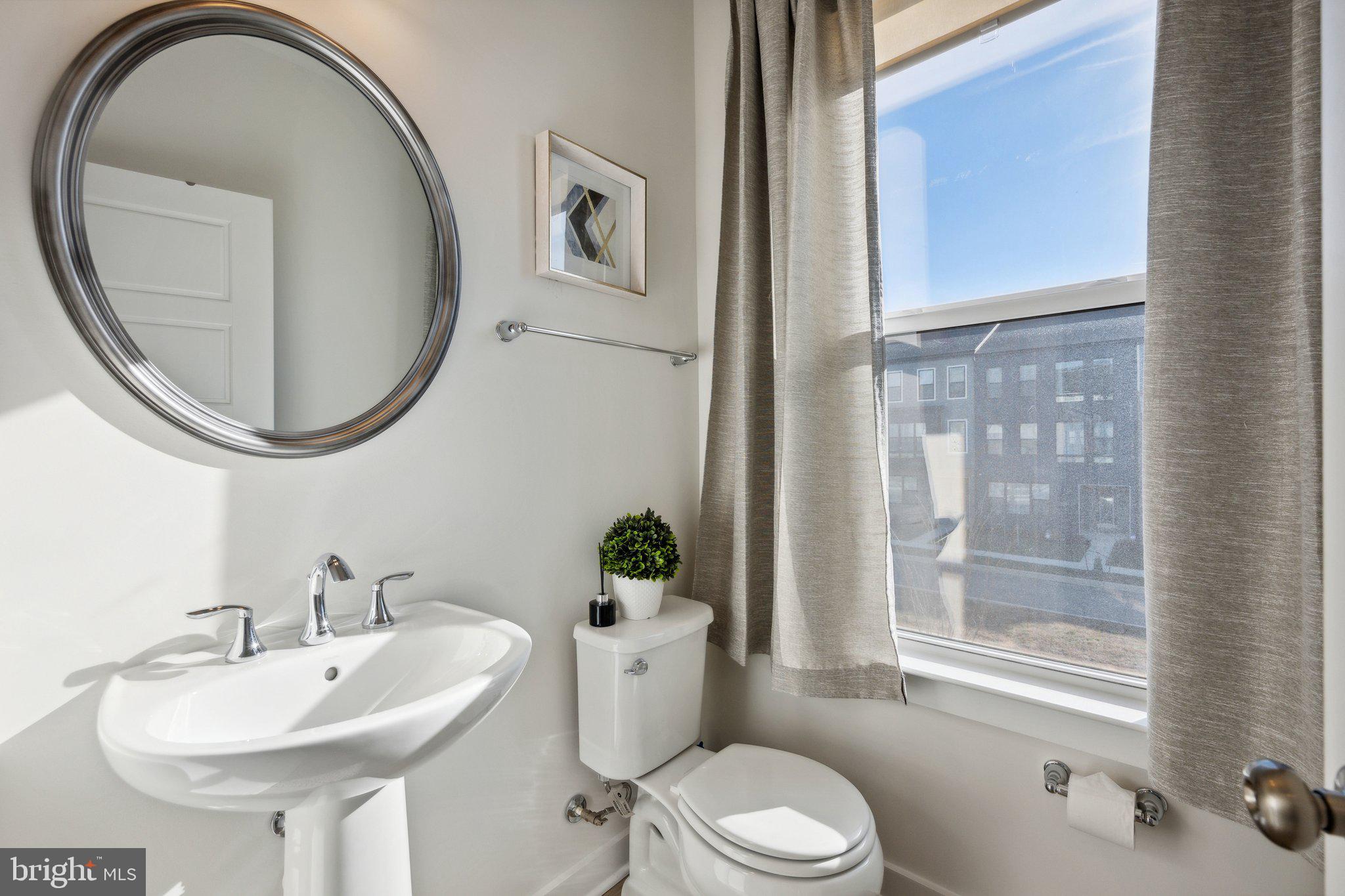319 Summit Point Boulevard Bowie, MD 20716 - Photo 9 of 28 a bathroom with a sink and mirror with toilet