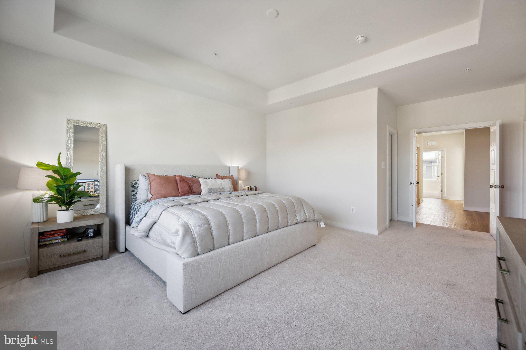319 Summit Point Boulevard Bowie, MD 20716 - Photo 10 of 28 a spacious bedroom with a bed and a potted plant