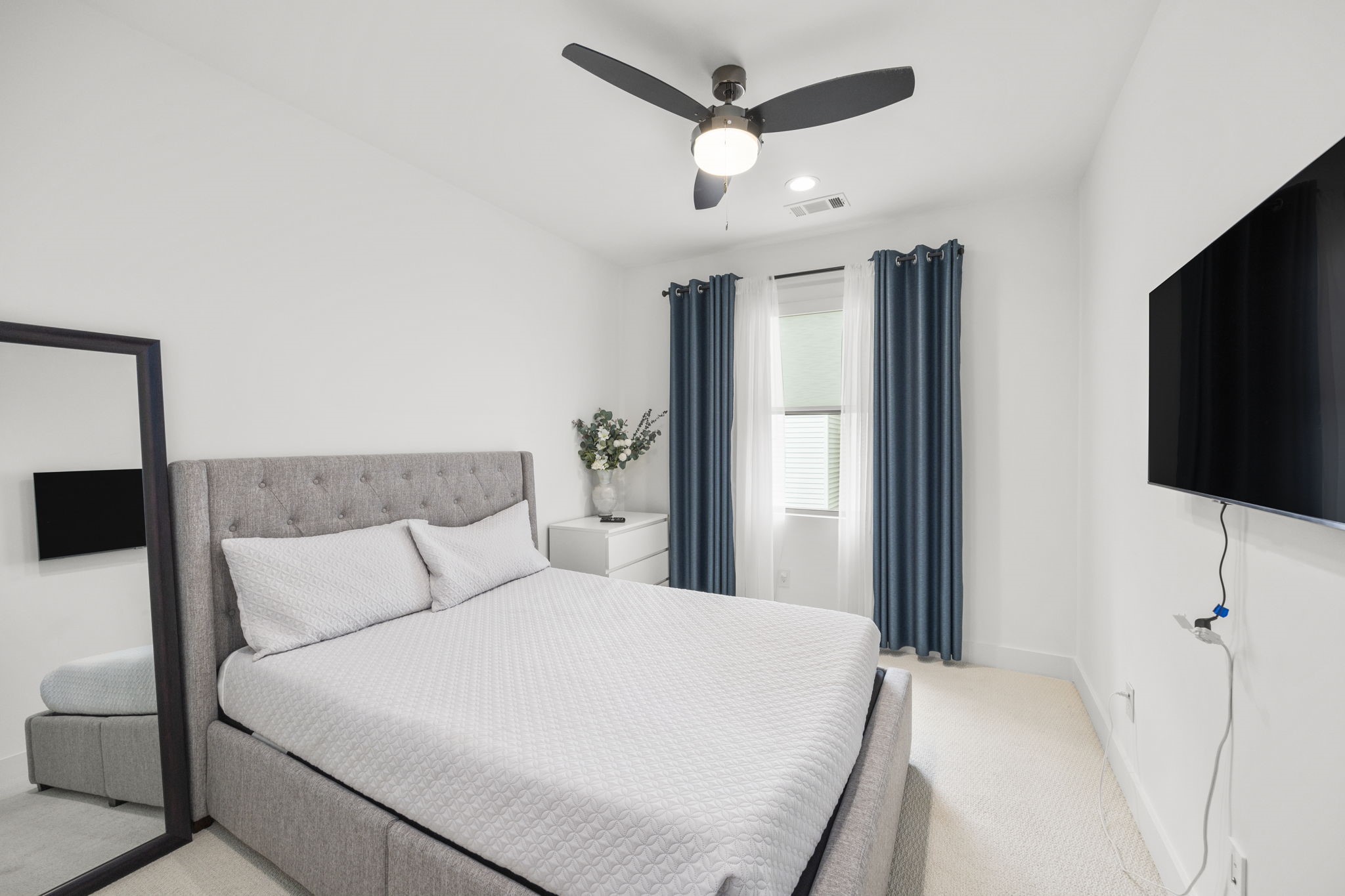2411 Hazard Street Houston, TX 77019 - Photo 34 of 46 The secondary bedroom offers a cozy and bright space with natural light flowing in from the window. The room features neutral tones and a modern ceiling fan, creating a comfortable and peaceful environment. Ideal for a guest room or additional bedroom, the space is simple yet elegant with soft carpet underfoot.