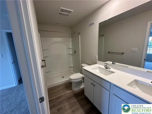 a bathroom with a sink a toilet and shower