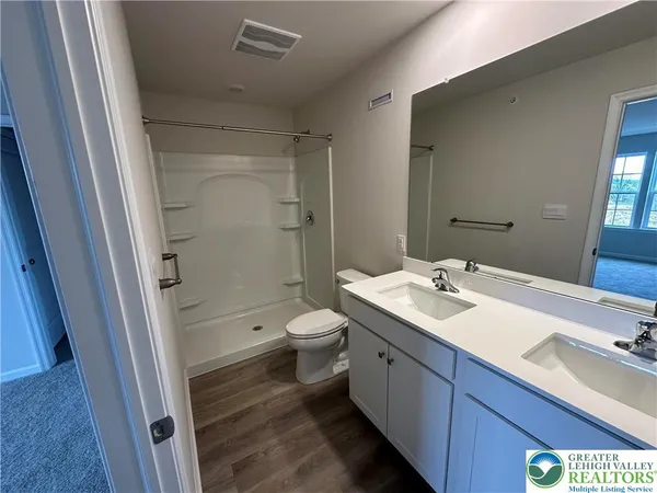 a bathroom with a sink a toilet and shower