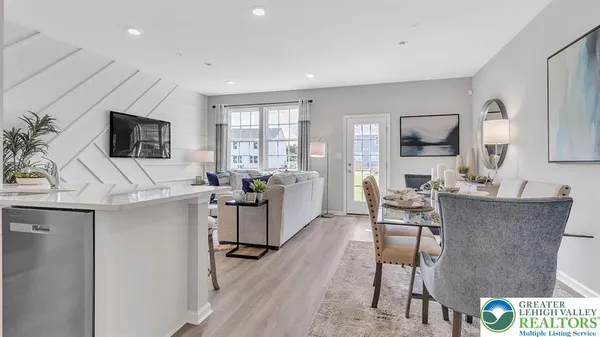 a living room with furniture a flat screen tv and a large window