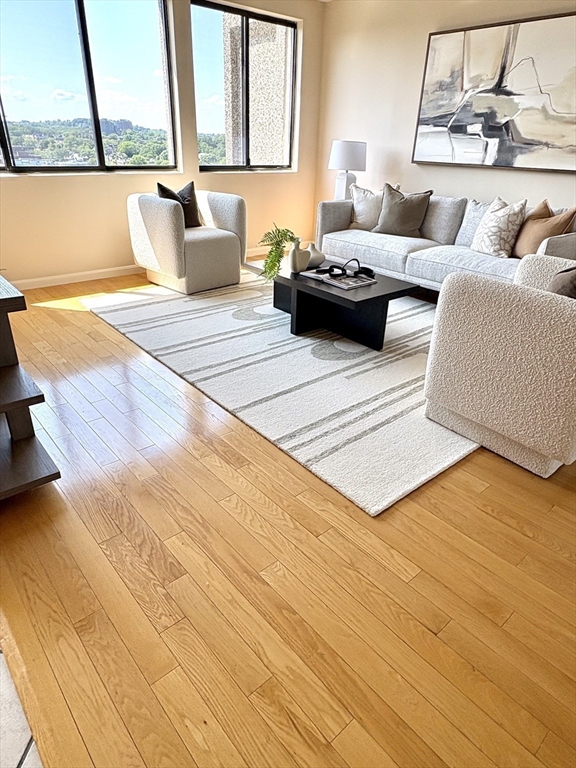 1731 Beacon Street, Unit 1502 Brookline, MA 02445 - Photo 9 of 27 a living room with furniture and a floor to ceiling window