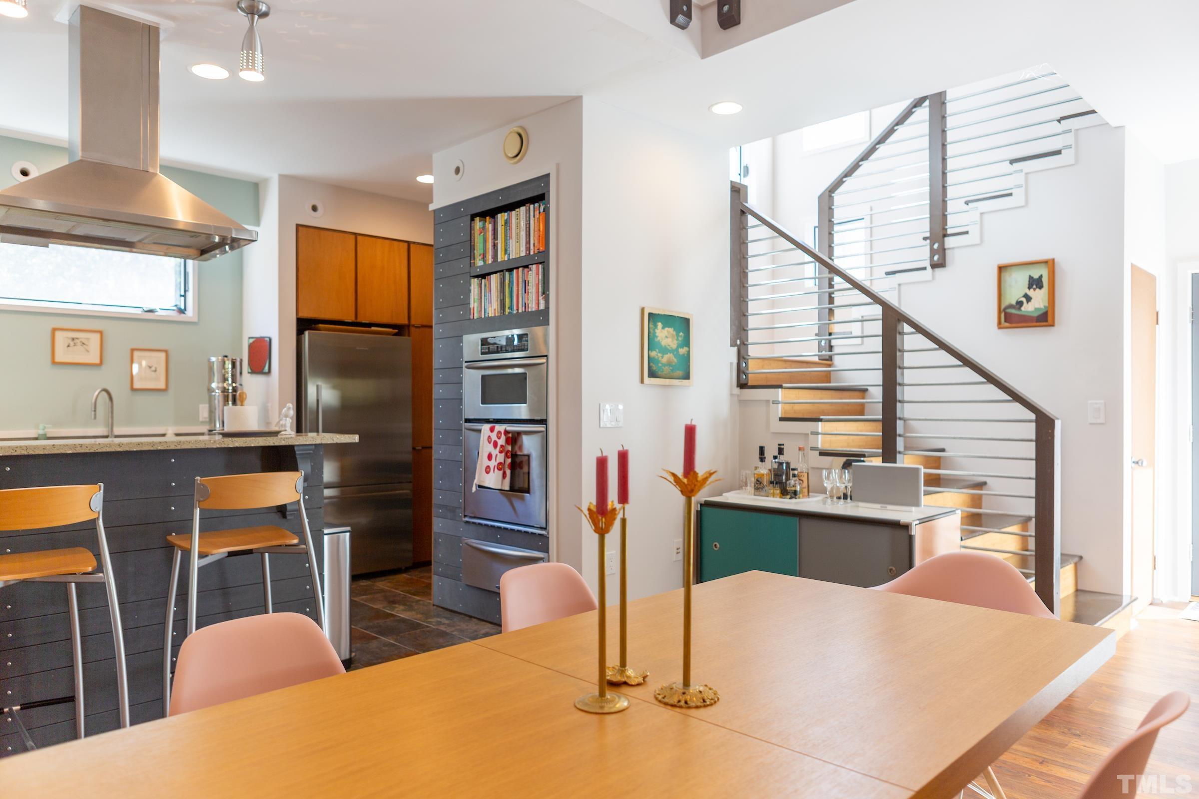 116 Solterra Way Durham, NC 27705 - Photo 16 of 30 a kitchen with stainless steel appliances kitchen island granite countertop a refrigerator a stove and a dining table with wooden floor